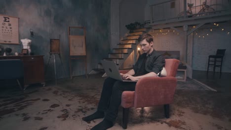 young man working on laptop in a cozy loft apartment