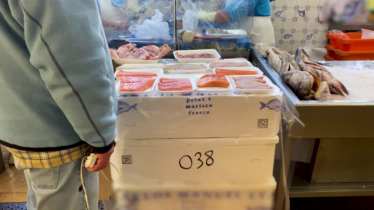 le signore al lavoro stanno sistemando o tagliando il filetto di salmone e sistemandolo su un bel vassoio da vendere al mercato di cascais