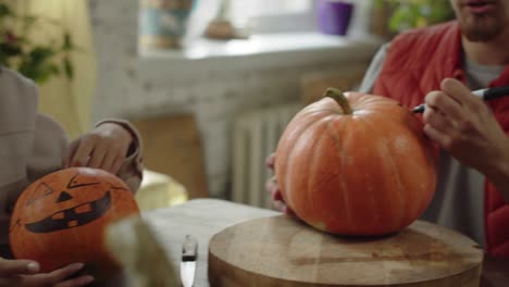 friends are painting the halloween pumpkins and talking