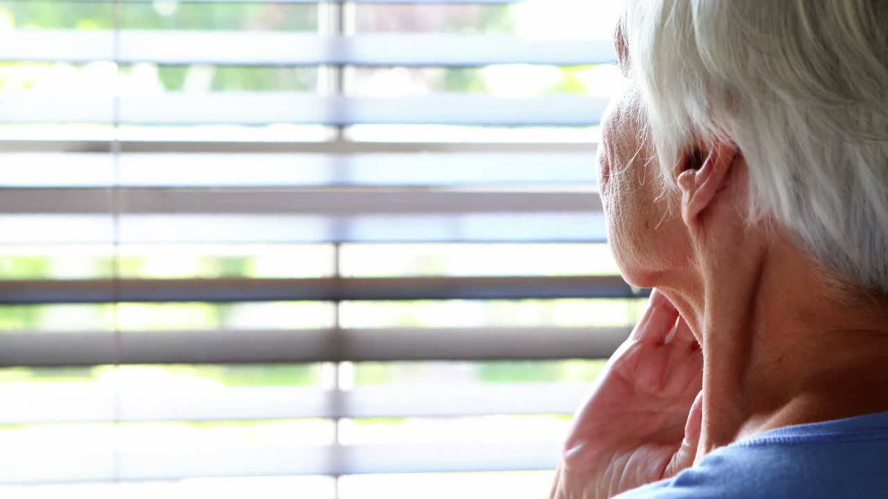 Senior woman looking out from window