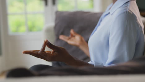 woman meditating on sofa at home wearing vr headset and interacting with ar technology