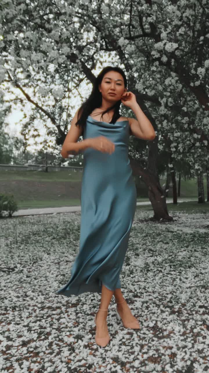 Woman in a Blue Satin Dress in a Spring Park