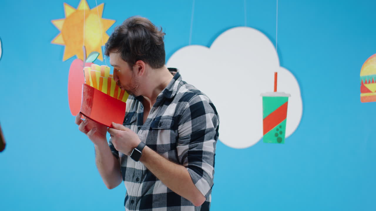 Man holding paper cutout of french fries