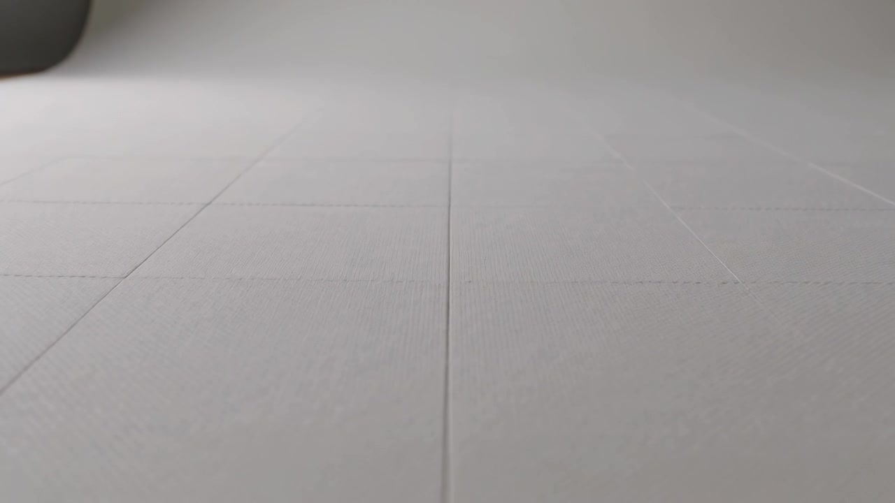 Shifting camera exposure revealing faint guide lines on sheet with crease on table