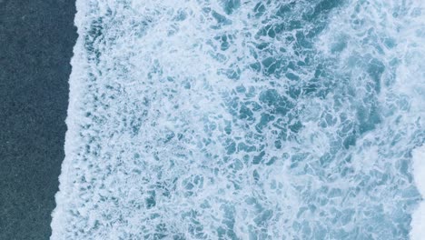 Top-Down-Slow-Motion-Drone-of-wave-action-at-low-tide-over-coral-and-rock-reef-Nyang-Nyang-Beach,-Bali,-Uluwatu-Indonesia