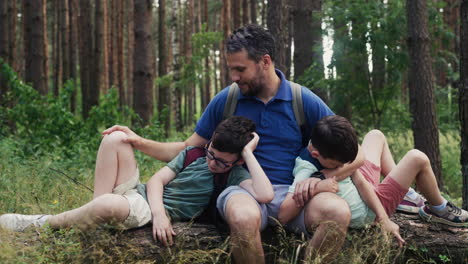 family sitting on trunk at the forest