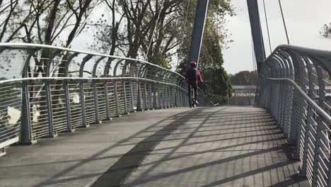 cyclist rides over pedestrian bridge in auckland new zealand