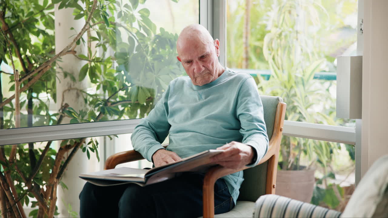 Elderly man reading an album