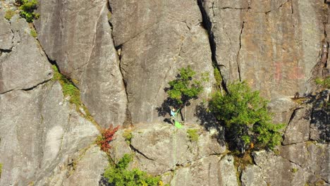 Aerial-footage-SLIDE-right-past-lone-hiker-on-a-cliff-in-Maine