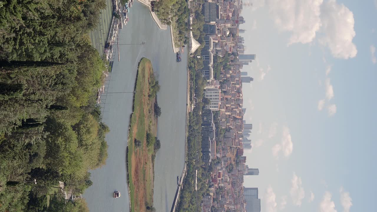Aerial view of a city with a river, island, and surrounding nature