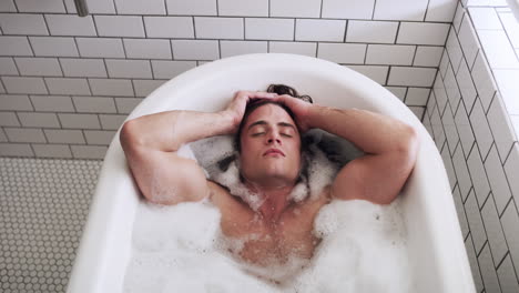 man relaxing in a bubble bath