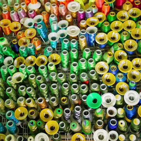 colorful sewing tools on a wall. rolls of threads hanging on a wall