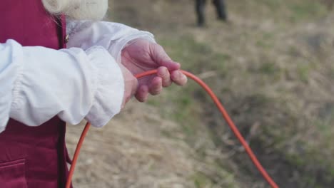 person in medieval costume holding a red rope