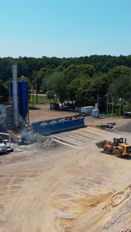 processing machine in sand quarry. aerial view of preparation for construction by different machines and equipment vertical video