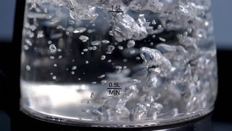 agua hirviendo rápidamente en una tetera de vidrio transparente, cámara lenta, cerrar