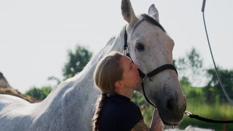 woman kisses a white horse