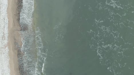 Aerial-shot-of-sandy-beach-and-cliff-in-Ustka-in-winter