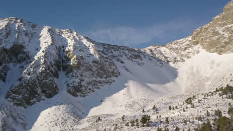 aéreo: hermosas y épicas montañas nevadas en una hermosa mañana, españa, adelante