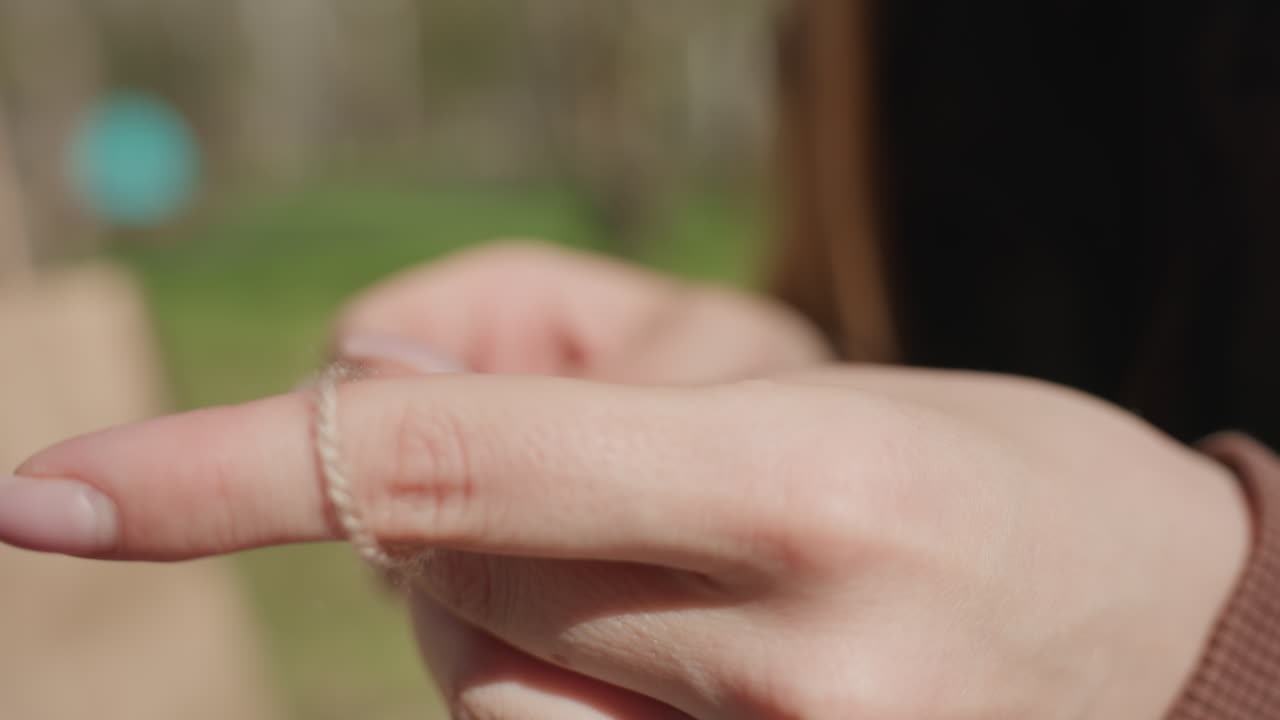 햇빛 아래 뜨개질하기, 평온한 여인이 자연 속에서 뜨개질을 하고 있어요. 여인이 야외에서 손뜨개 바늘로 작품을 만드는 평화로운 장면, 햇살 가득한 공원에서 한가롭게 뜨개질을 하는 아시아 여성의 고요한 이미지