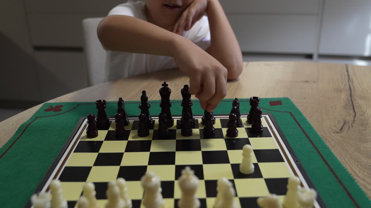 Un bambino che gioca a scacchi su una scacchiera