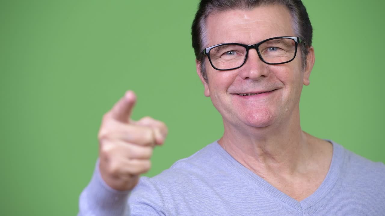 Senior handsome man pointing at camera