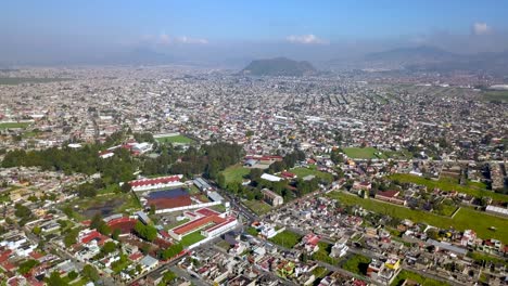 Top-drone-view-of-downtown-the-charming-town-of-chalco-Mexico,-and-view-of-the-downtown-and-roads-towards-Mexico-City