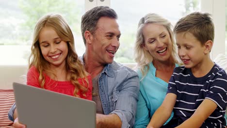 Glückliche-Familie-Mit-Laptop-Im-Wohnzimmer