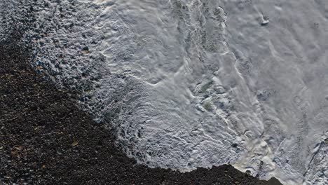 Above-View-Of-Foamy-Waves-Over-Sandy-Shoreline