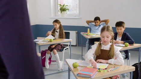 grupo multiétnico de estudiantes sentados en pupitres en clase de inglés