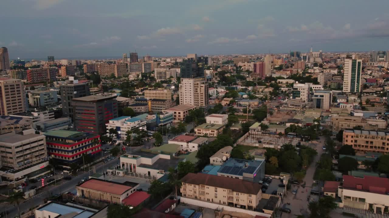 Aerial drone shot of cityscape in Kenya, buildings and roads visible below, with cloudy sky overhead, showcasing the urban landscape and natural surroundings.