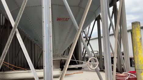 Panning-shot-of-a-worker-pulling-a-rope-to-allow-the-feed-out-of-the-silo