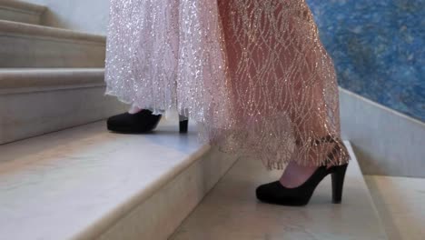 girl in long dress climbs marble villa stairs