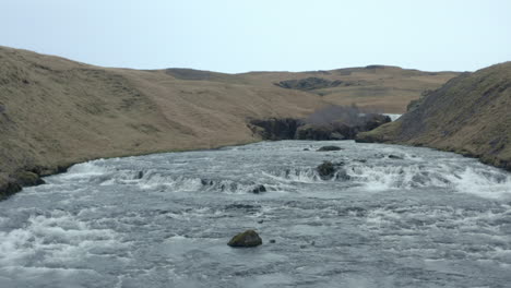 close up reveal shot over the top of skógafoss waterfall iceland