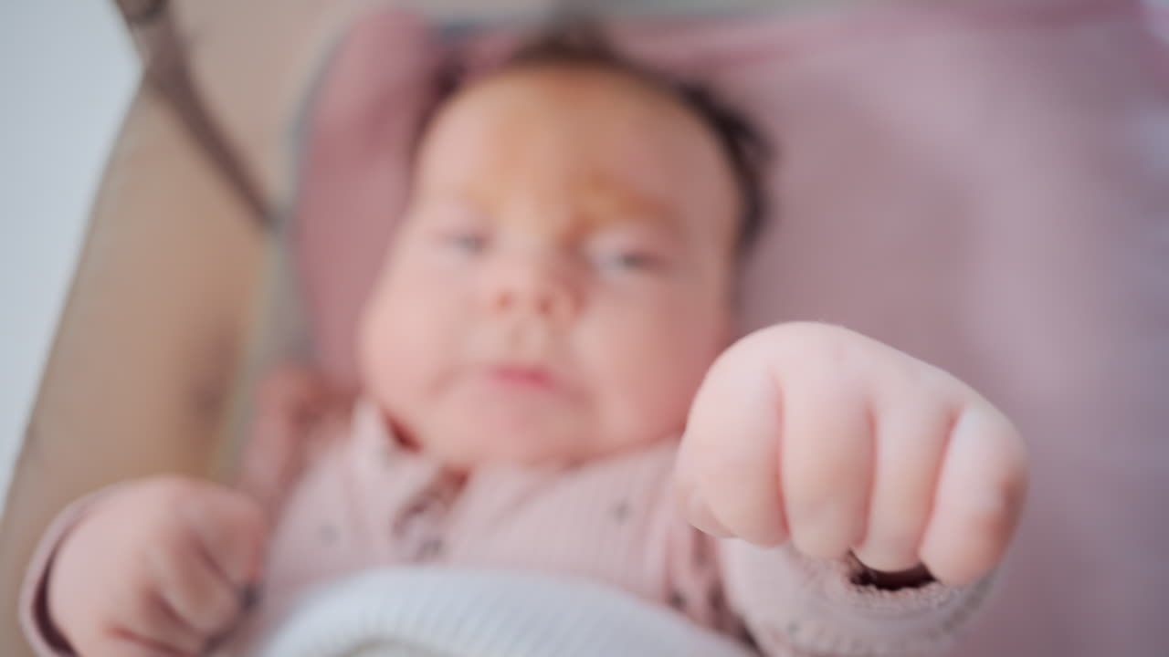 Close up of baby's tiny hand reaching out gently in soft pastel tones