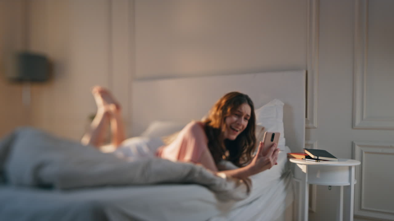 아침에 비디오 통화를 하는 즐거운 소녀. 웃는 여성이 드폰을 흔들고