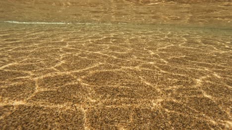 Sunlight-reflection-from-Ocean-waves-shimmer-on-the-sand,-natural-pattern