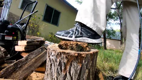 male cutting lumber in the backyard for fire wood