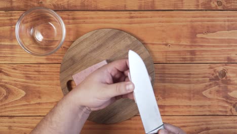 man slices ham close up