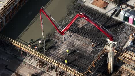 construction workers during concrete pouring with boom concrete pump at the site