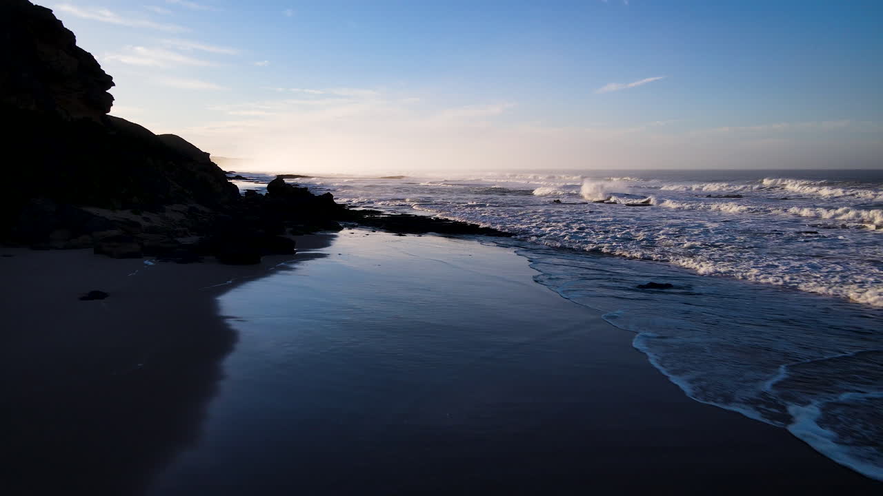 vuelo de drones bajo el amanecer sobre la prístina playa de la ruta del jardín, sudáfrica