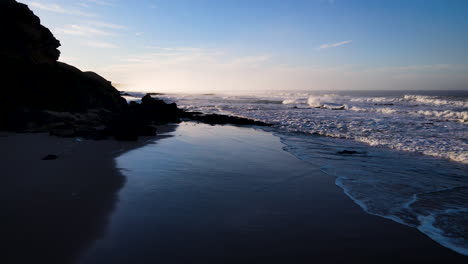 Low-sunrise-drone-flight-over-pristine-Garden-Route-beach,-South-Africa