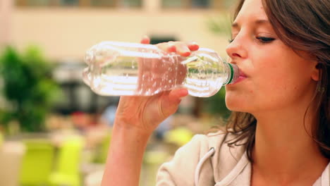 estudiante feliz bebiendo agua en la cantina