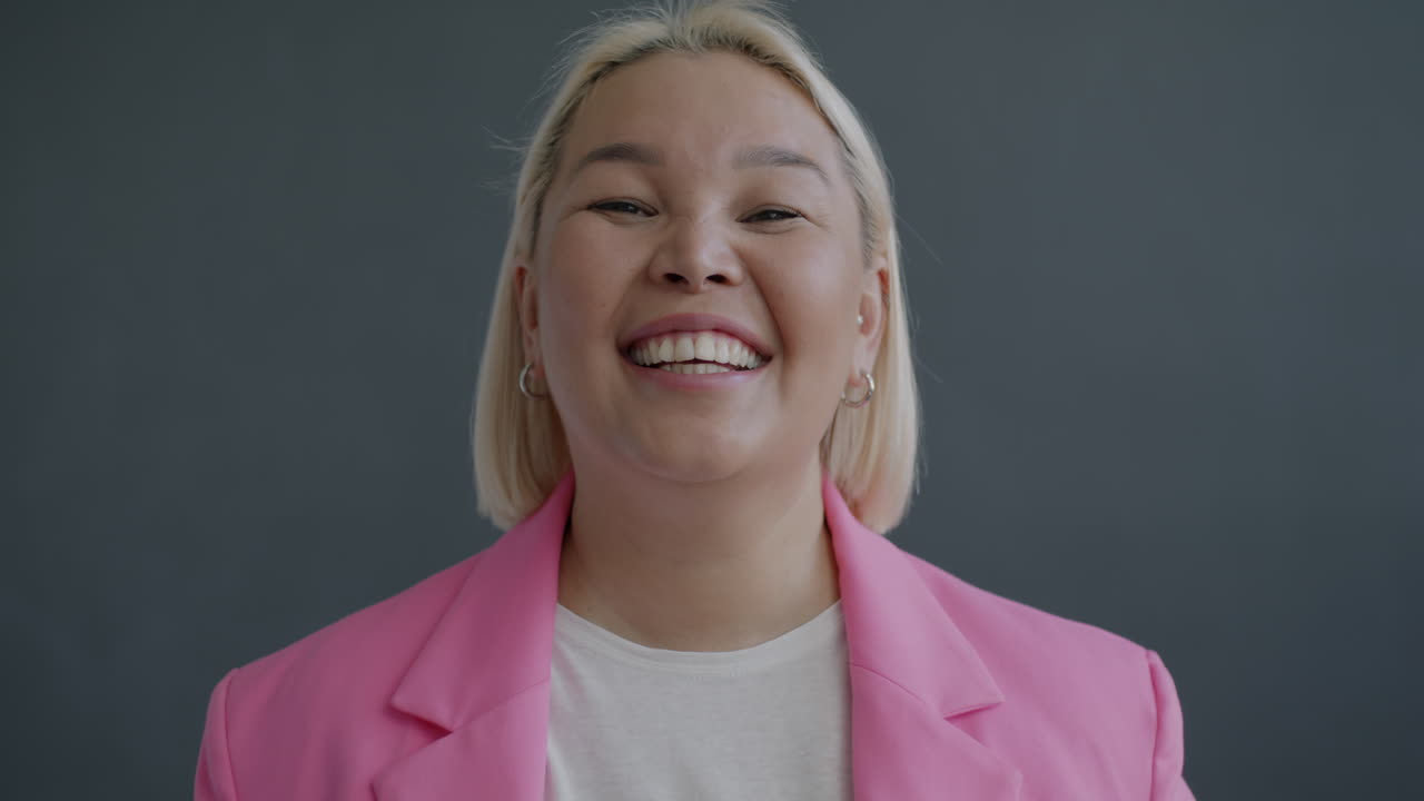 분홍색 블레이저를 입은 행복한 여자