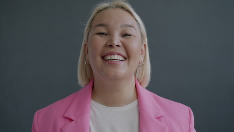 una mujer feliz con una chaqueta rosa.