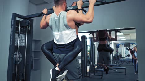 young couple is working out at gym. attractive woman and handsome muscular man are training in light modern gym