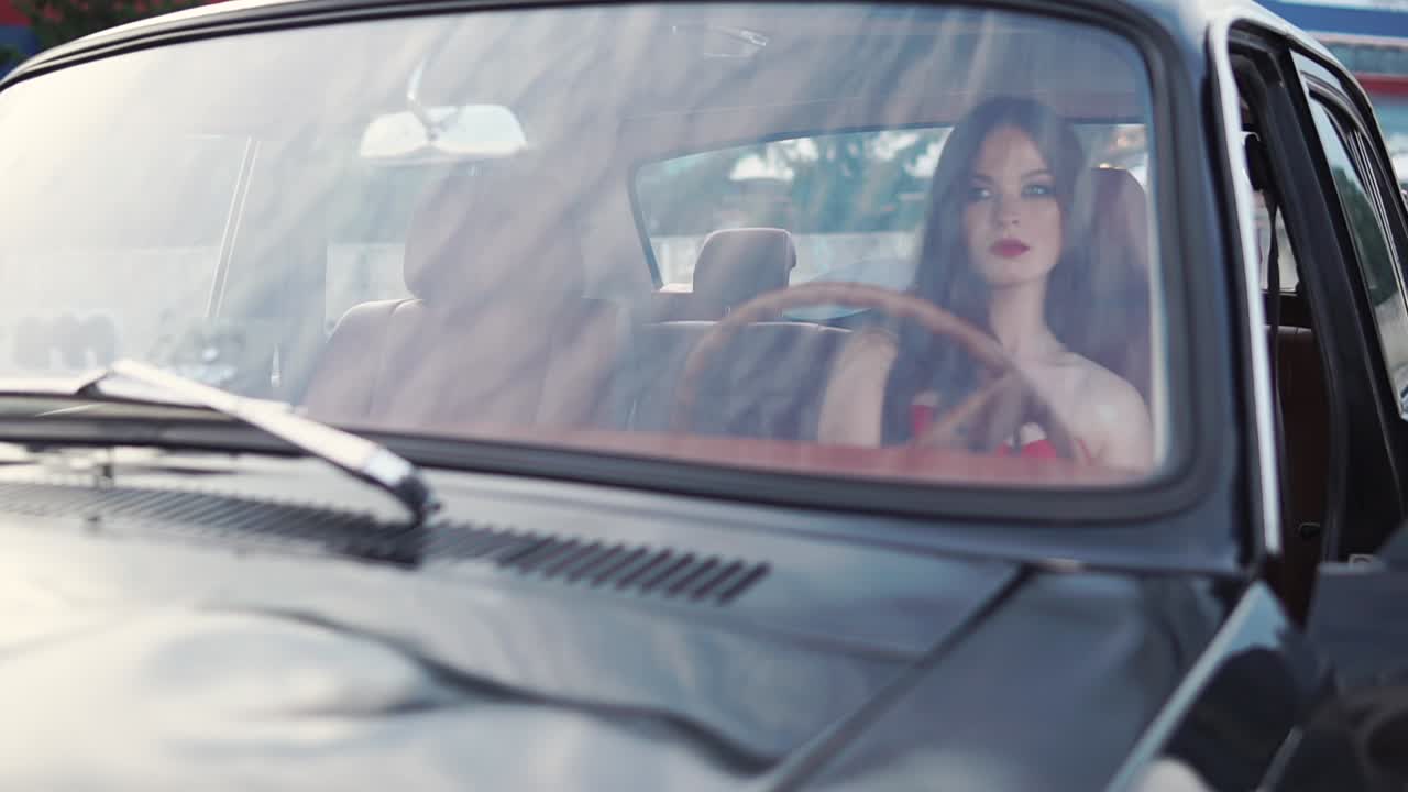 Donna alla guida di un'auto d'epoca