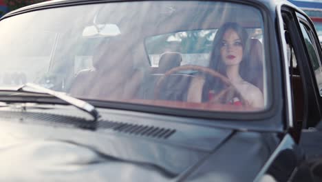 una mujer conduciendo un coche de época.