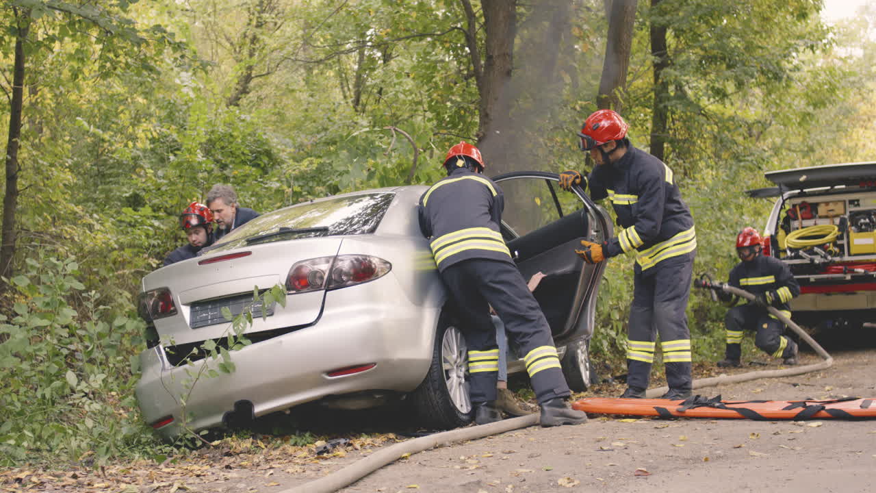 Firefighters Rescuing Victims from a Car Accident in a Forest