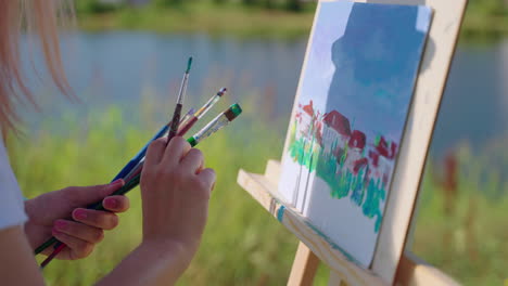 woman painting outdoors by a lake