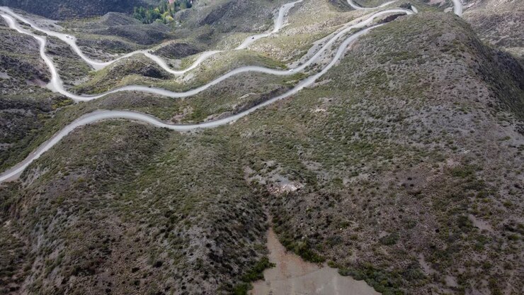 Un sorvolo rivela tornanti tortuosi mentre la strada scende dal passo di montagna